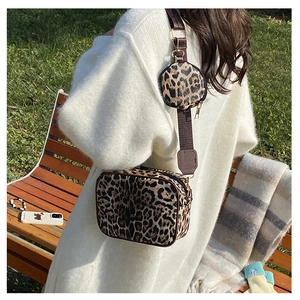 Detail view of leopard print crossbody bag with detachable round mini purse on strap