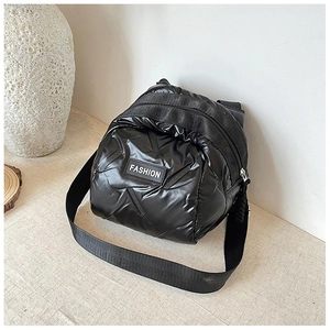 Detail of black puffer crossbody bag with FASHION label and quilted nylon texture
