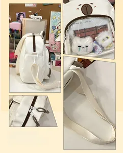 Detail showing transparent window for plushies on white canvas shoulder bag with bear face
