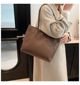 Detail of coffee brown leather tote bag with vertical stitching for a commuter look