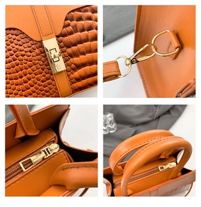 Detail of orange crocodile pattern handbag featuring golden twist lock and metal hardware