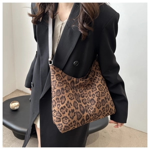 Close-up of leopard print shoulder bag worn by model featuring premium plush texture