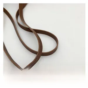 Détail de la bandoulière en cuir marron avec couture de précision et texture naturelle