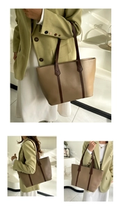 Detail of a large khaki tote bag showing contrast brown straps and spacious commute design
