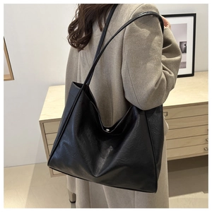 Detail of a black leather tote bag showing soft textured material and spacious interior
