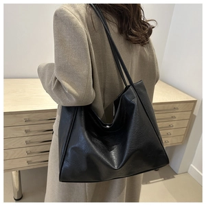 Detailed back view of a black large-capacity tote bag worn on shoulder by a model