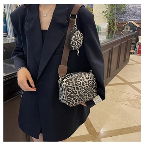 Detailed view of leopard print crossbody bag with mini pouch and wide strap on black blazer