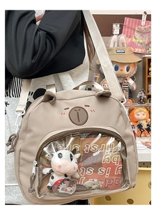 Close-up of beige cartoon bear crossbody bag with a clear window for dolls and badges