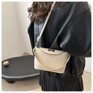 Détail du sac à bandoulière en cuir grainé beige avec fermoir en métal doré élégant