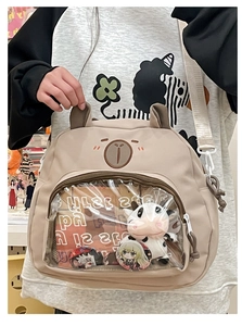 Detail view of the brown bear-themed ita bag with clear window and plush toy insert