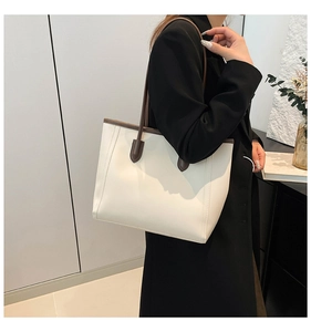 Detail view of large white shoulder tote bag with contrasting dark brown leather straps