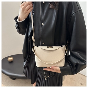 Détail du sac seau blanc crème à grain de litchi avec fermoir tournant doré et bandoulière