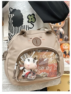 Detail of beige cartoon bear ita bag with a large transparent display window and charms