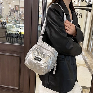 Metallic silver padded crossbody bag with adjustable strap and fashion label detail