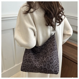 Detailed view of the large leopard print tote bag worn as a crossbody shoulder bag