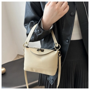 Gros plan d'un sac à main en cuir grainé blanc cassé avec fermoir rotatif doré élégant