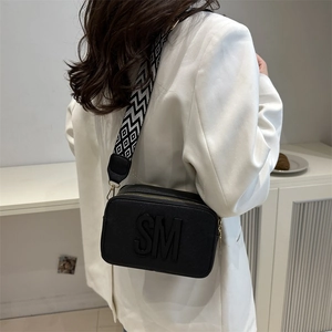 Chic black camera bag with SM lettering and geometric woven wide shoulder strap
