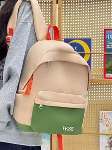 Detail view of contrast color backpack with TKSS logo shown on a shoulder strap