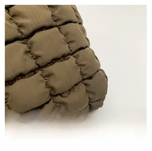 Macro shot of quilted puff clouds texture on khaki waterproof nylon handbag material