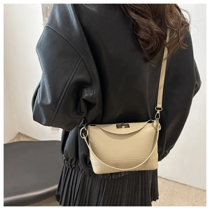 Détail du sac bandoulière beige à motif lychee avec fermoir tournant doré sur mannequin