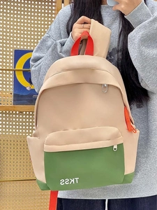 Detailed close-up of colorful nylon backpack with red handle and green zipper pocket