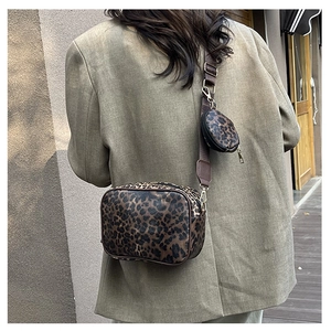 Street style view of leopard print crossbody bag set with mini coin purse on olive suit