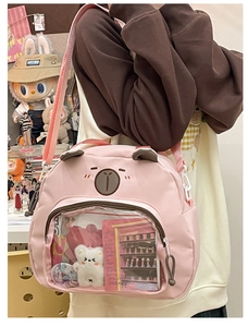 Close-up of pink bear canvas ita bag with a clear PVC window showing plush dolls and pins