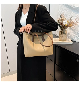 Chic beige and brown contrast tote bag styled with casual commuter outfit in a modern room