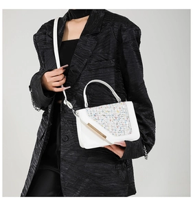 Mannequin portant un petit sac blanc avec texture tissée et boucle métallique dorée
