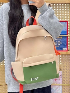 Detail of color-block backpack with orange straps and green pocket for students