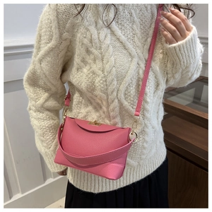 Sac seau rose montrant la texture cuir litchi et les détails de boucle dorée