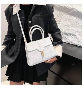 White crocodile pattern shoulder bag featuring a gold twist lock on a black outfit