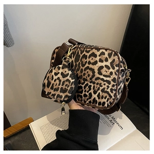 Detail of leopard print crossbody bag set featuring a matching round coin purse with strap
