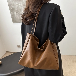 Brown large capacity faux leather tote bag for women showing a stylish shoulder carrying style