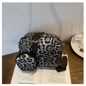 Detail of leopard print crossbody bag set with small round coin purse on a recipe book