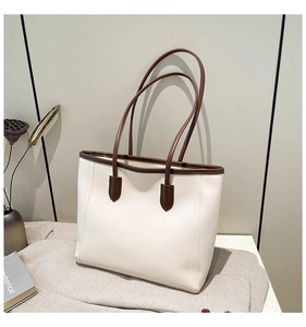 Detail view of large cream tote bag with contrast brown straps for commute