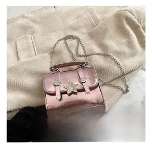 Detail of pink metallic crossbody bag featuring star-shaped buckle and textured surface