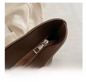 Close-up of a smooth silver metal zipper on a brown vintage leather tote bag detail