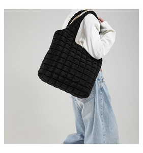 Detail view of black quilted puff hobo bag with soft nylon texture and padded shoulder strap