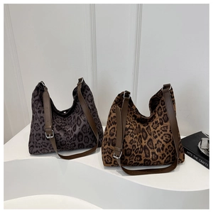 Detail view of leopard print tote bags in grey and brown with adjustable leather straps