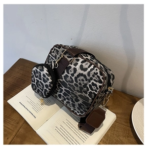 Detail of leopard print crossbody bag set with wide shoulder strap and gold hardware