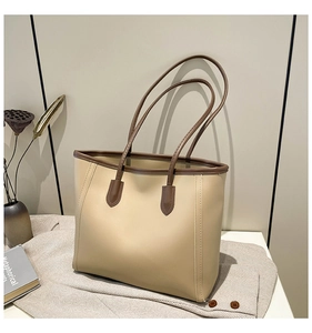 Detailed close-up of beige and brown tote bag stitching and leather texture