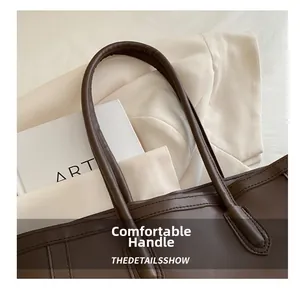 Detail showing high-quality leather handle with clean stitching on brown tote bag