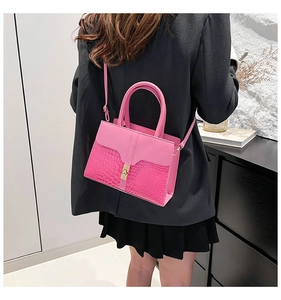 Pink lady crossbody bag with crocodile texture and golden metal buckle shown on a model