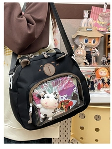 Detail of black canvas ita bag with bear ears, embroidery, and a clear display window