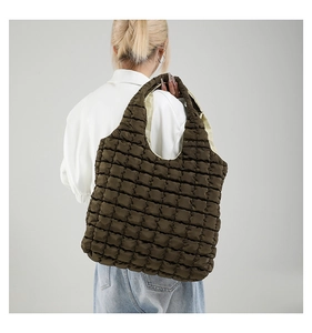 Detail of dark brown quilted bubble tote bag showing textured puffy fabric on shoulder