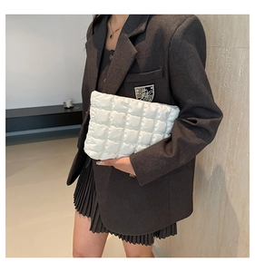 Dettaglio di una borsa a mano trapuntata bianca in pelle PU portata da una modella