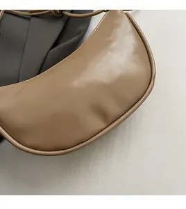Detailed view of the khaki crescent moon bag showing premium leather texture and logo