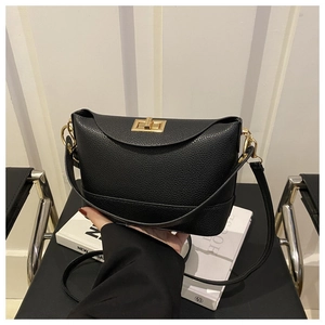 Détail du sac seau noir en cuir grainé avec fermoir rotatif carré en métal doré