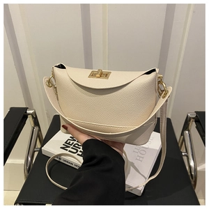 Détail de près d'un sac en cuir grainé crème avec fermoir rotatif en métal doré chic